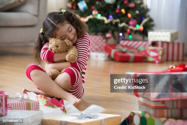 little girl opening christmas presents in living room - kidstock girl stock pictures, royalty-free photos & images