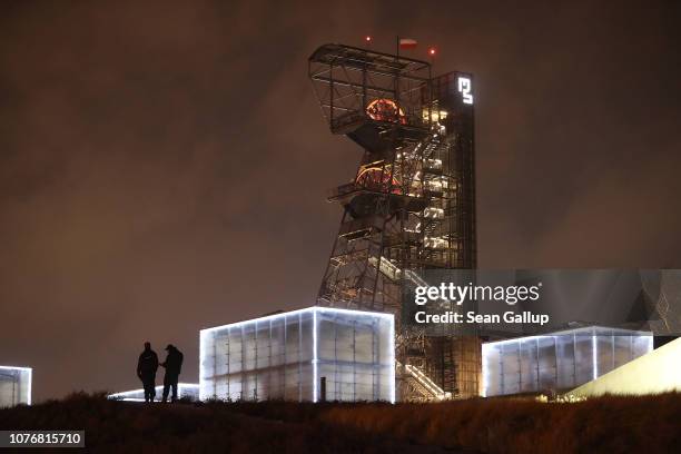 Police stand under a former coal mine elevator tower, now part of the Silesian Museum, next to the venue of the COP 24 United Nations climate change...