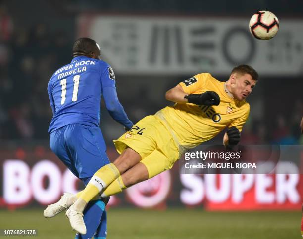 Aves' French goalkeeper Quentin Beunardeau heads the ball beside Porto's Malian forward Moussa Marega during the Portuguese League football match...