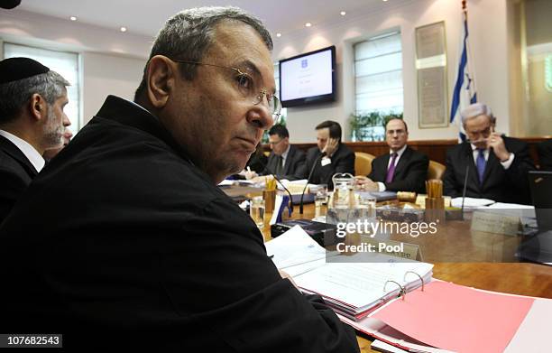 Israeli Prime Minister Benjamin Netanyahu chairs the weekly cabinet meeting in his Jerusalem offices as Defense Minister Ehud Barak pauses while...