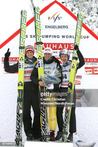 Second place Thomas Morgenstern of Austria celebrates with first place winner Andreas Kofler of Austria and third place Adam Malysz of Poland after...