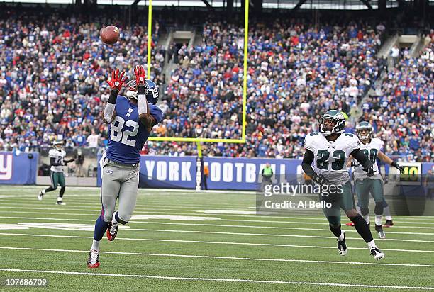 Mario Manningham of the New York Giants scores a touchdown in the first quarter as Dimitri Patterson and Colt Anderson of the Philadelphia Eagles...