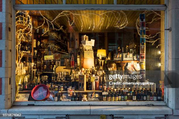 the view from kinds of drinks store showcase at night in bruges, belgium - belgium beer stock pictures, royalty-free photos & images