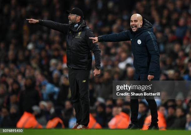 Josep Guardiola, Manager of Manchester City and Jurgen Klopp, Manager of Liverpool give their team instructions during the Premier League match...