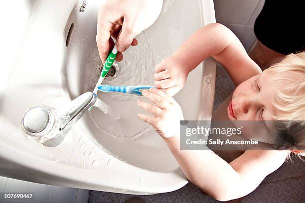 child brushing his teeth with daddy - hand wash stock pictures, royalty-free photos & images