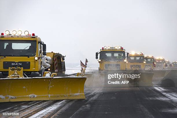 Snow ploughs clear a runway at Schiphol International Airport in Amsterdam on December 19, 2010. Heavy snow disrupted the Christmas holiday getaway...