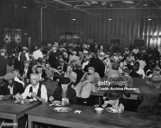 Homeless men eating in the main dining hall of the Municipal Lodging House on East 25th Street, New York City, circa 1935. The building, which...