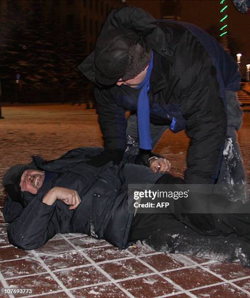 Belarus opposition candidate Andrei Sannikov lies on a street after being beaten during a clash between protesters and police in Minsk early on...