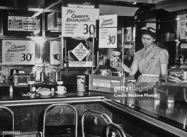 Waitress behind the counter of a diner specializing in Quaker oatmeal dishes, USA, circa 1935.