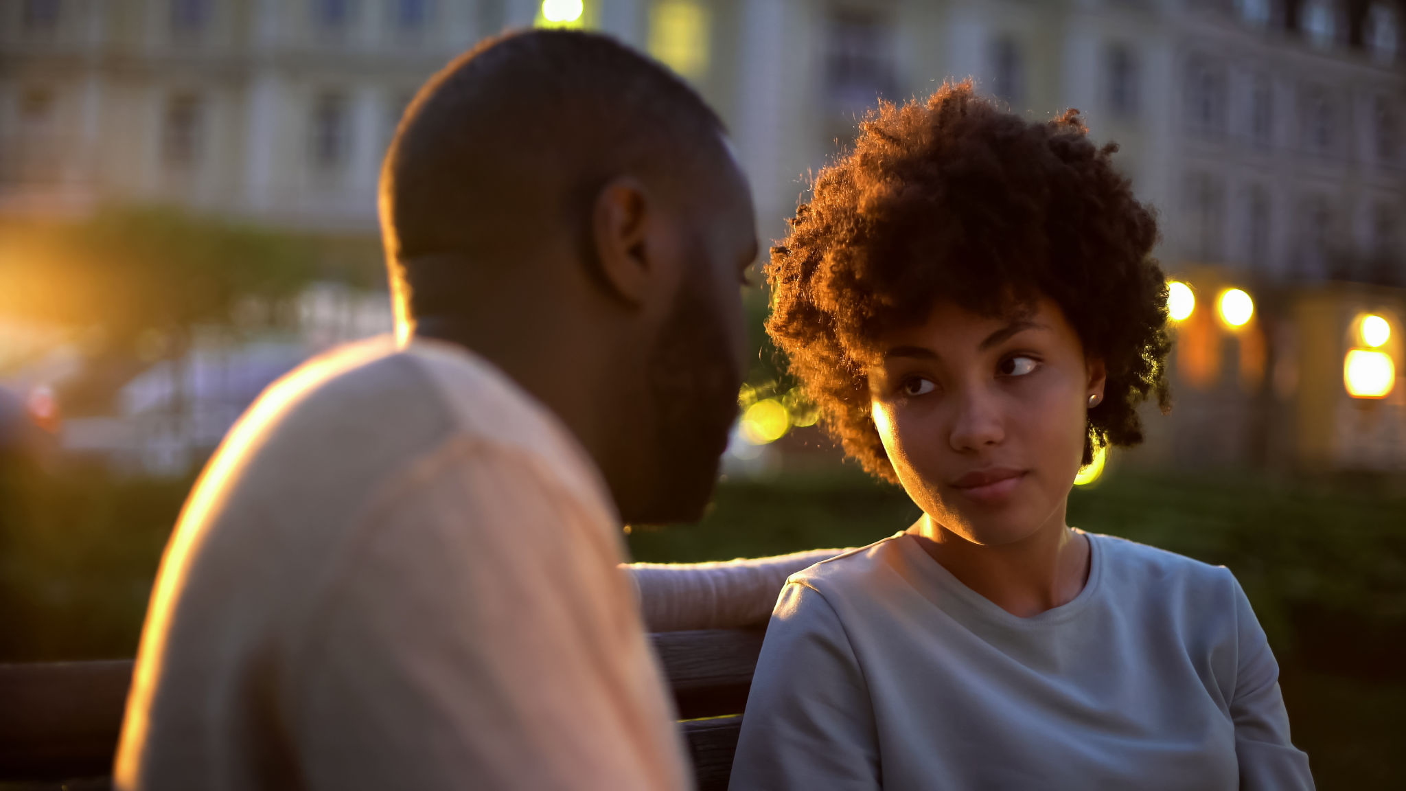Offended woman looking at boyfriend, outdoor date, misunderstanding, conflict Offended woman looking at boyfriend, outdoor date, misunderstanding, conflict