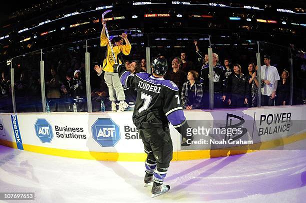 Rob Scuderi of the Los Angeles Kings gives his stick to a fan after defeating the Calgary Flames at Staples Center on December 9, 2010 in Los...