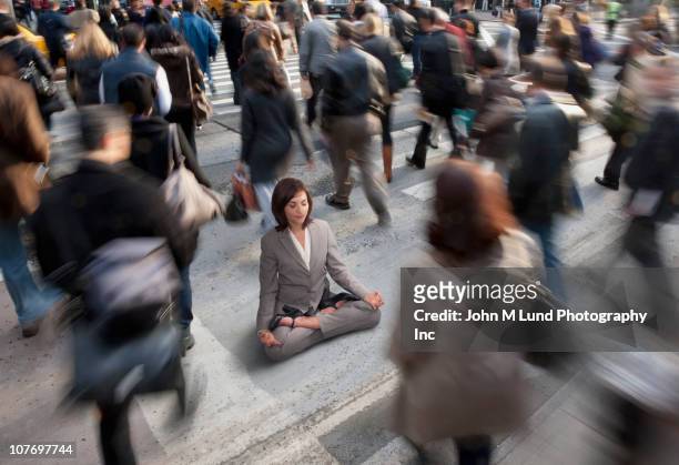 mixed race businesswoman practicing yoga in busy urban crosswalk - soul city ストックフォトと画像