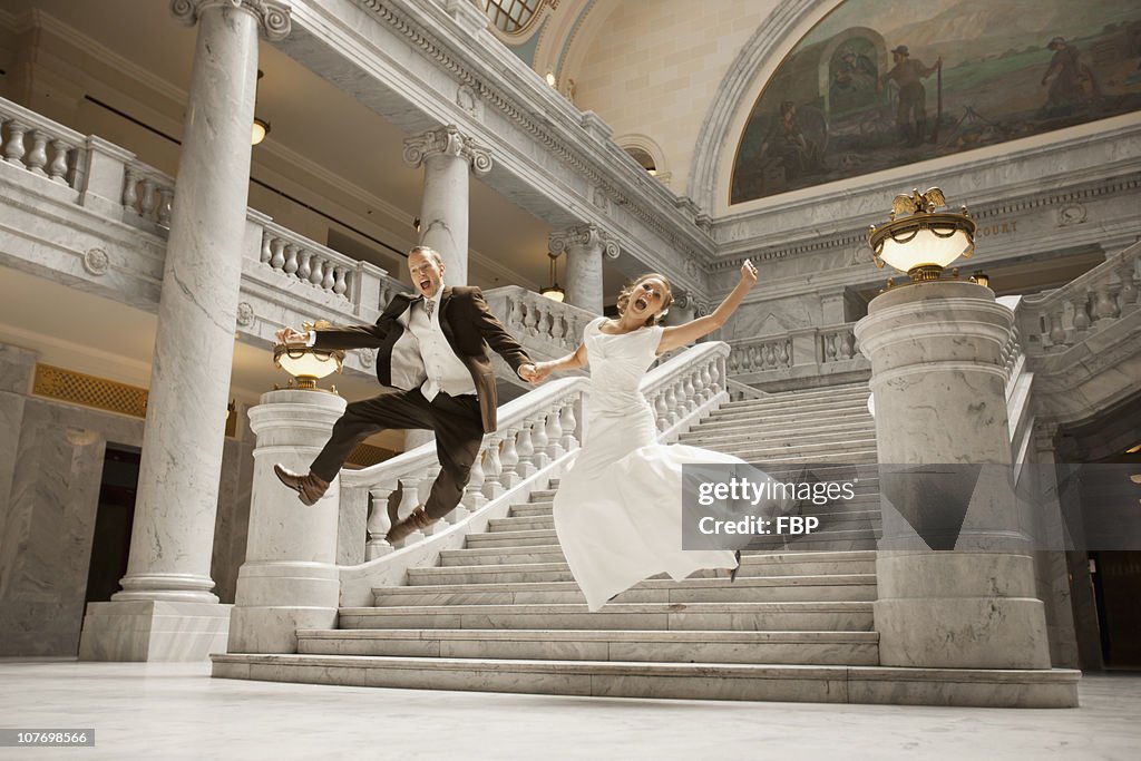 USA, Utah, Salt Lake City, Bride and groom leaping from steps