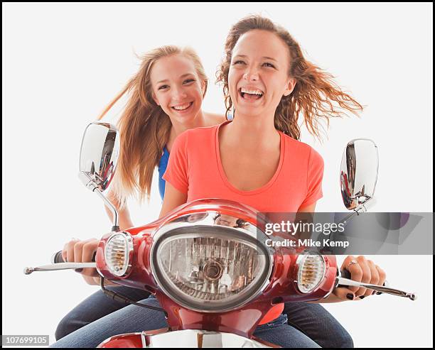 young girls (16-17,16-17) riding scooter - girl riding scooter stockfoto's en -beelden