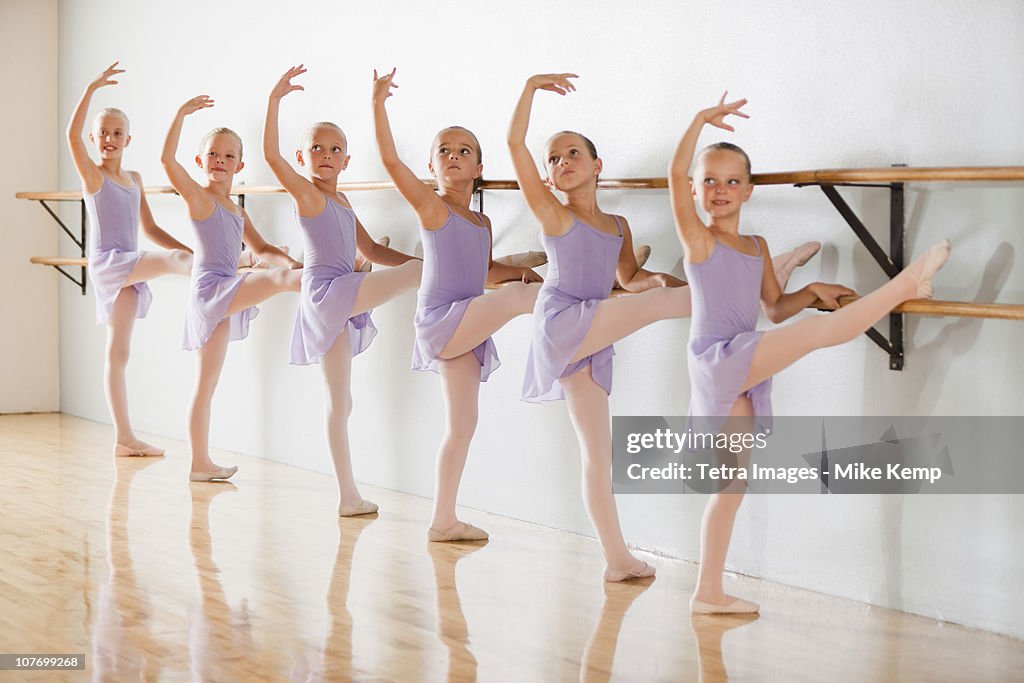 Row of female ballet dancers (6-7,8-9) in dance studio