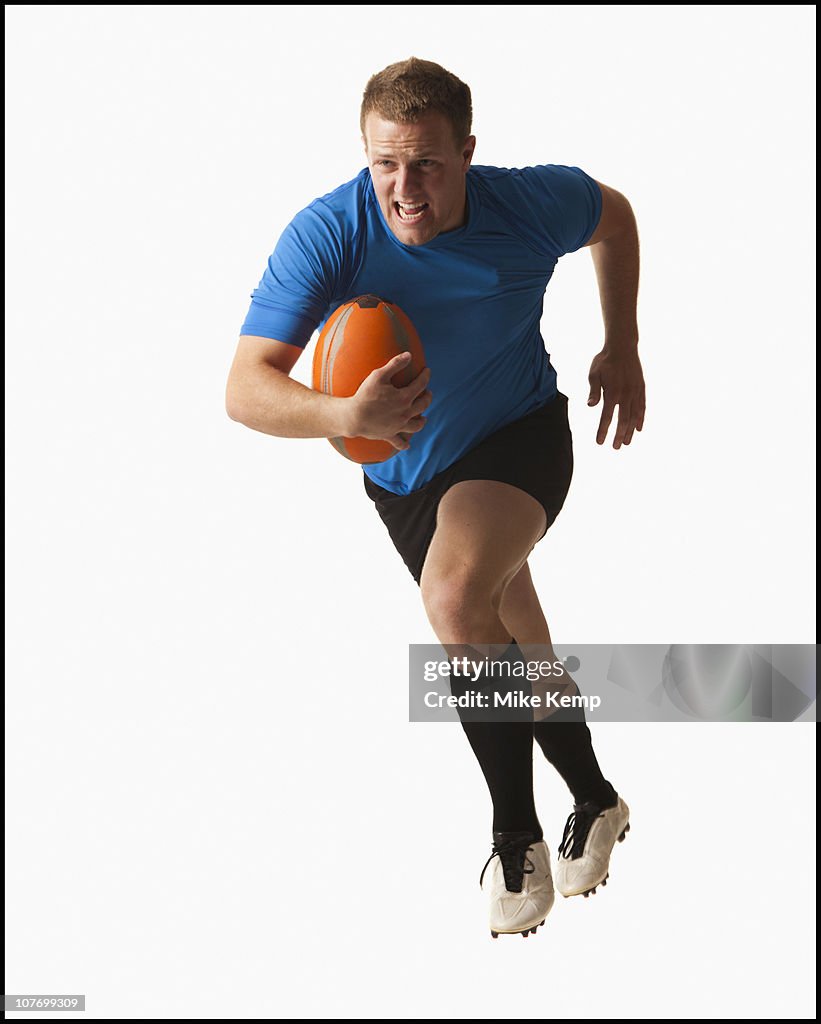 Male rugby player running with ball