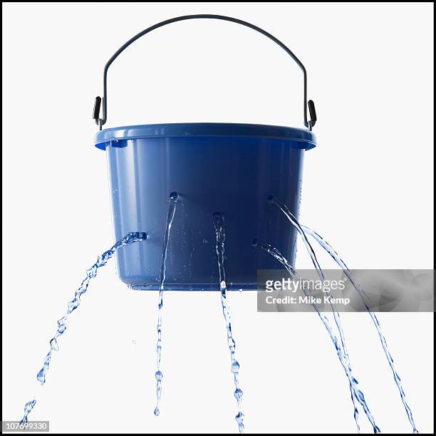 studio shot of leaking bucket - bucket stock pictures, royalty-free photos & images