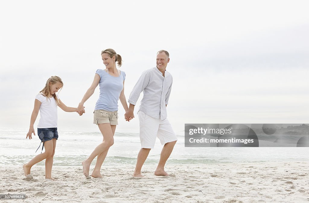 South Africa, Parents with daughter (10-11) walking on beach