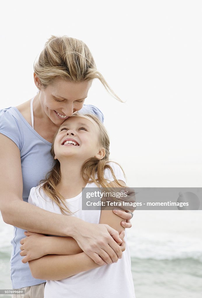 South Africa, Mother with embracing daughter (10-11) on beach