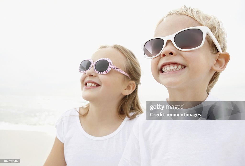 South Africa, Portrait of brother (4-5) and sister (10-11) wearing sunglasses on beach