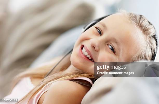 south africa, girl (10-11) laying on back, listening to mp3 player - lying on back girl on the sofa stock-fotos und bilder