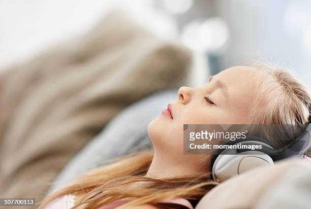 south africa, girl (10-11) laying on back, listening to mp3 player - lying on back girl on the sofa stock-fotos und bilder