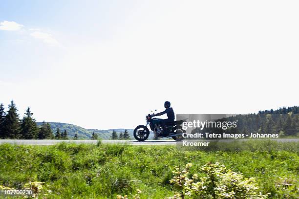 germany, thuringia, suhl, motorbike on country road - moto carretera fotografías e imágenes de stock