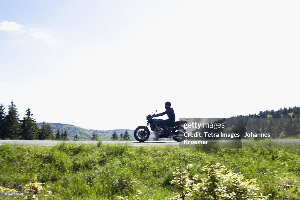 Germany, Thuringia, Suhl, Motorbike on country road
