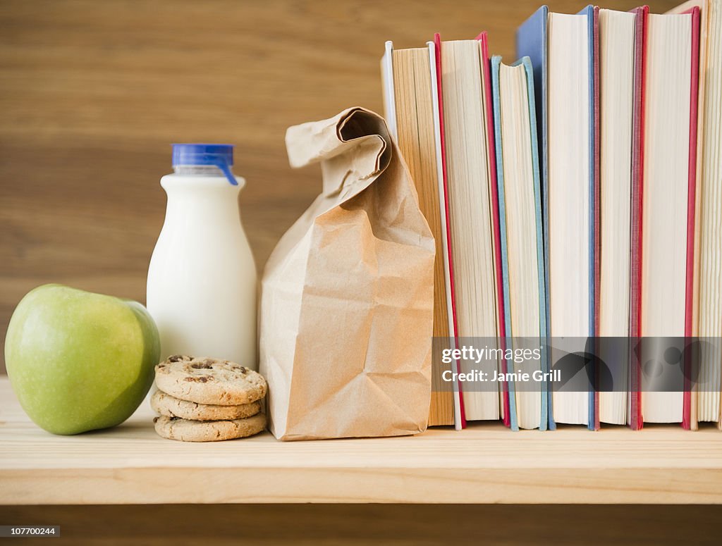 Row of books and lunch bag on shelf