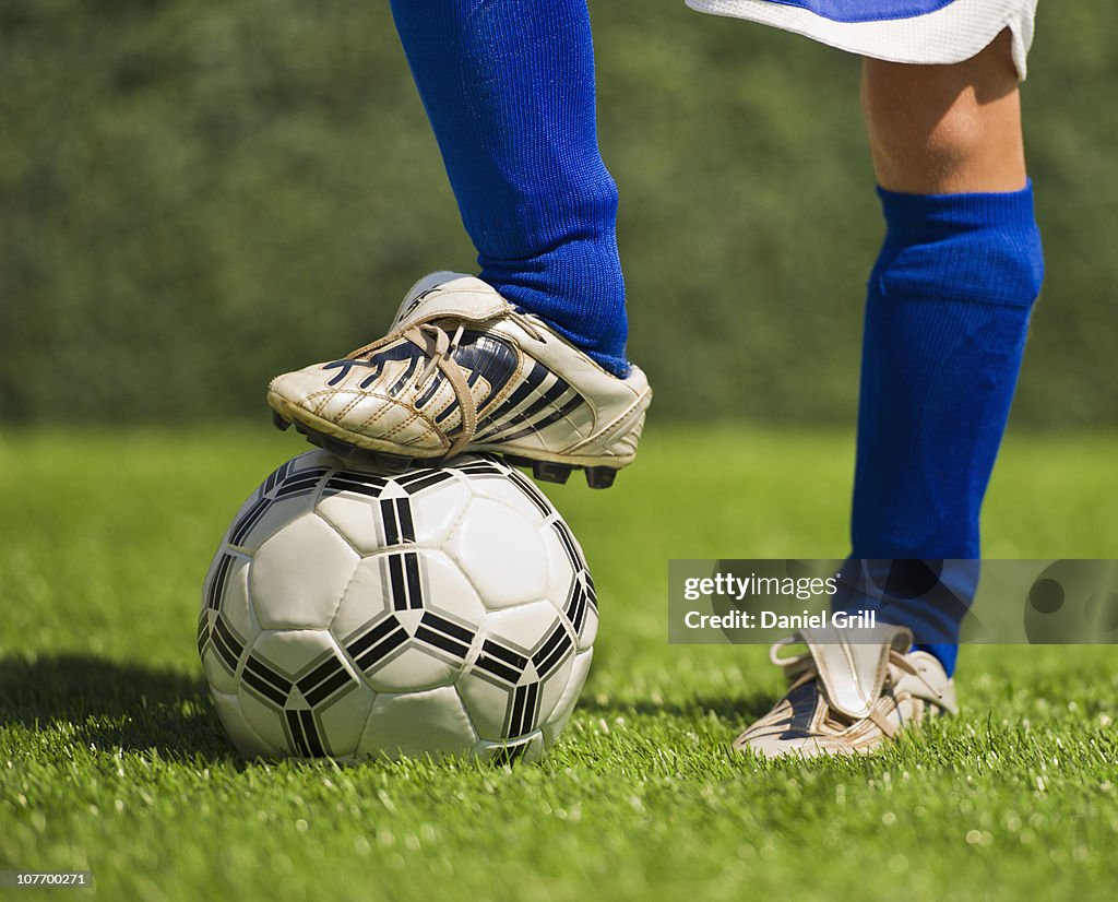 USA, New Jersey, Jersey City, Low section of boy (10-11) playing soccer