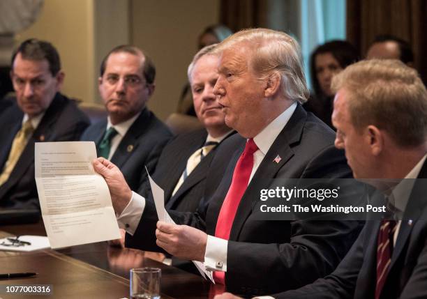 President Donald Trump holds up a letter purportedly from North Korean leader Kim Jong Un as he leads a meeting of his Cabinet, on January 2019 in...