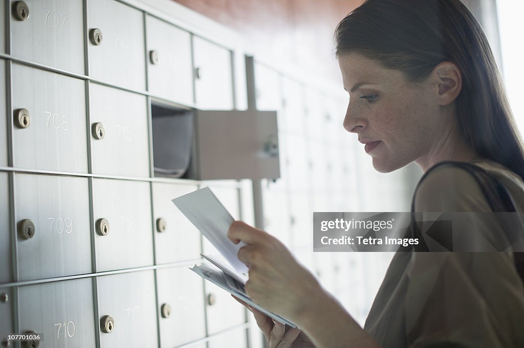 USA, New Jersey, Woman taking letters from mailbox