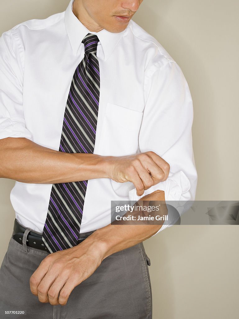 Businessman rolling up sleeves