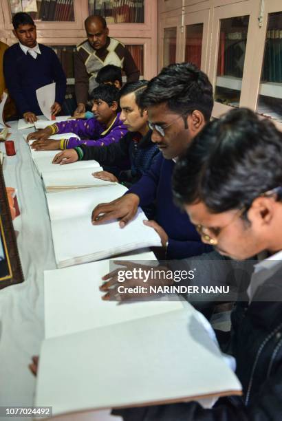 Visually impaired Indian students read using the Braille system on the occasion of the 210th birth anniversary of its French inventor Louis Braille...
