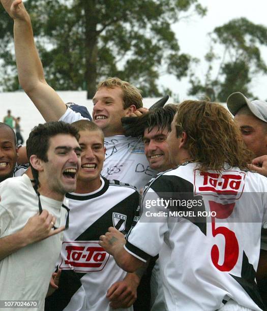 Marcelo "Pato" Sosa captain of the Danubio team celebrates with teammates and fans the obtainment of the Clausura Tounament, 24 November 2002, after...
