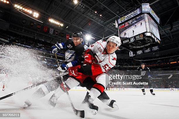 Mike Lundin of the Tampa Bay Lightning battles for the puck against Jeff Skinner of the Carolina Hurricanes at the St. Pete Times Forum on December...