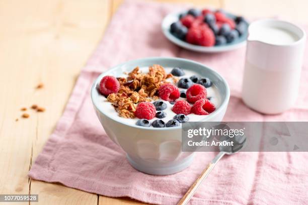 yogurt with granola and berries in bowl - granola stock-fotos und bilder