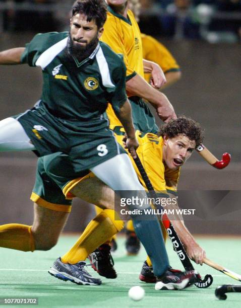 Australian captain Brent Livermore gets a shot away on goal in front of Pakistan defender Tariq Imran during their match in Sydney, 05 June 2003....