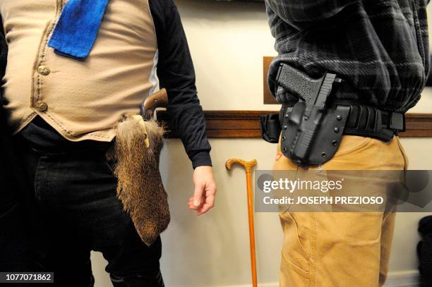 Two men dressed as patriots carry guns during the opening day of the House of Representatives at the New Hampshire State House, where the House will...