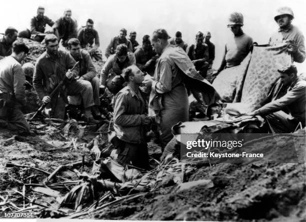 Some American Soldiers Attending The Mass At The Peak Of Mount Suribachi On The Island Of Iwo Jima On March 6, 1945. One Of The Marines Gets The...