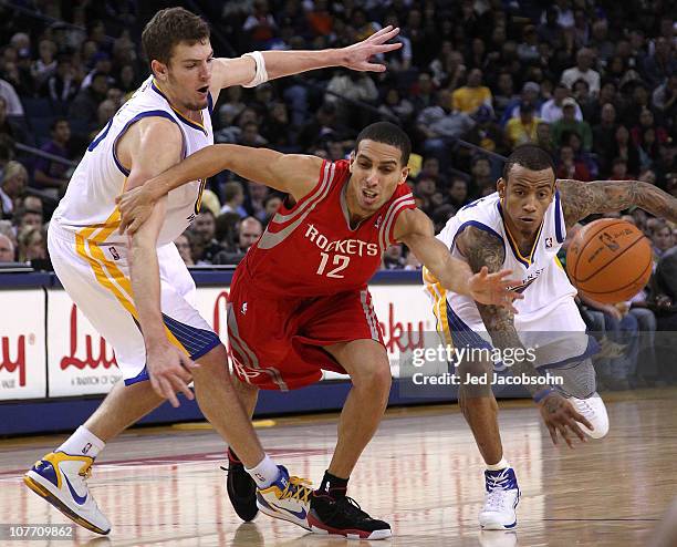 Kevin Martin of the Houston Rockets battles for the ball with David Lee and Monta Ellis of the Golden State Warriors during an NBA game at Oracle...