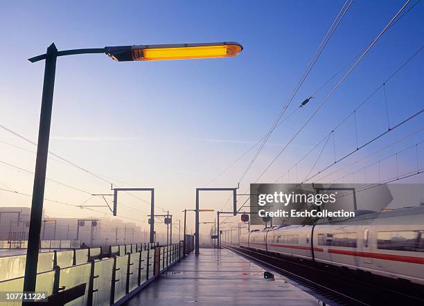 fast ice train leaving a station in amsterdam. - ice zug stock-fotos und bilder