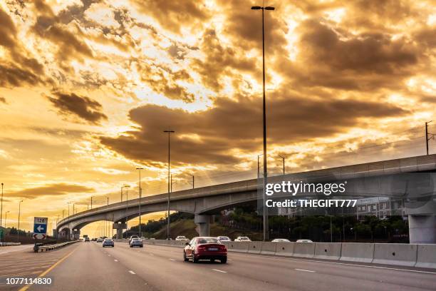 n1 highway with gautrain metro bridge under storm clouds - centurion south africa stock pictures, royalty-free photos & images