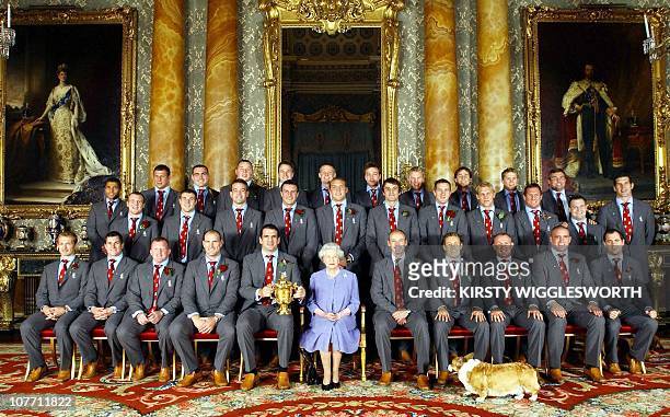 Britain's Queen Elizabeth II poses 08 December with the England rugby squad at a reception at Buckingham Palace in London to celebrate winning the...