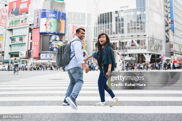 asian couple on a trip running at shibuya crossing - southeast asian ethnicity stock pictures, royalty-free photos & images