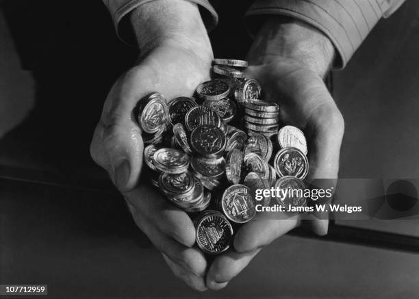 Close up of a man with a handful of American coins.