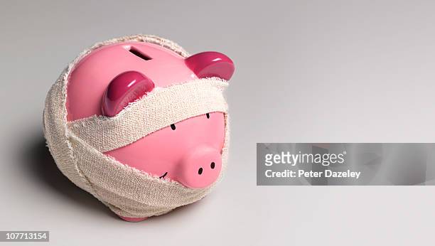 ill piggy bank with bandages - unfall konzepte stock-fotos und bilder