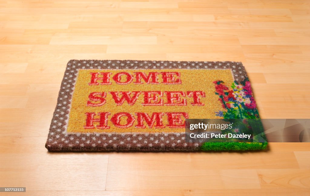 Home sweet home doormat on wooden floor