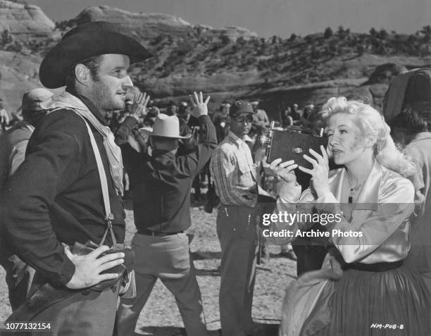 American actress Marilyn Maxwell films co-star Jack Briggs on the set of the film 'New Mexico', USA, 1951.
