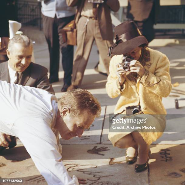 American actor Charlton Heston plants his handprints in cement outside Grauman's Chinese Theatre, Hollywood, California, 18th January 1962. He is...